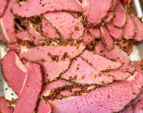 Sliced pastrami pieces on a tray.