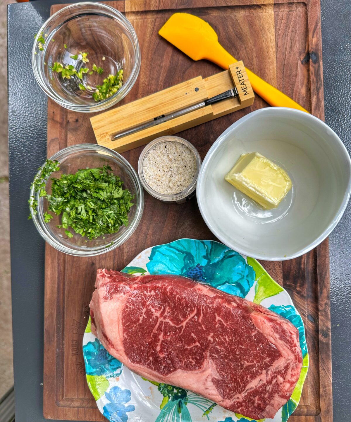Steak and compound butter ingredients on a cutting board.
