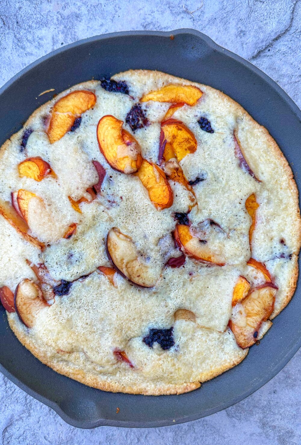 Peach and blackberry cobbler in a cast iron skillet.