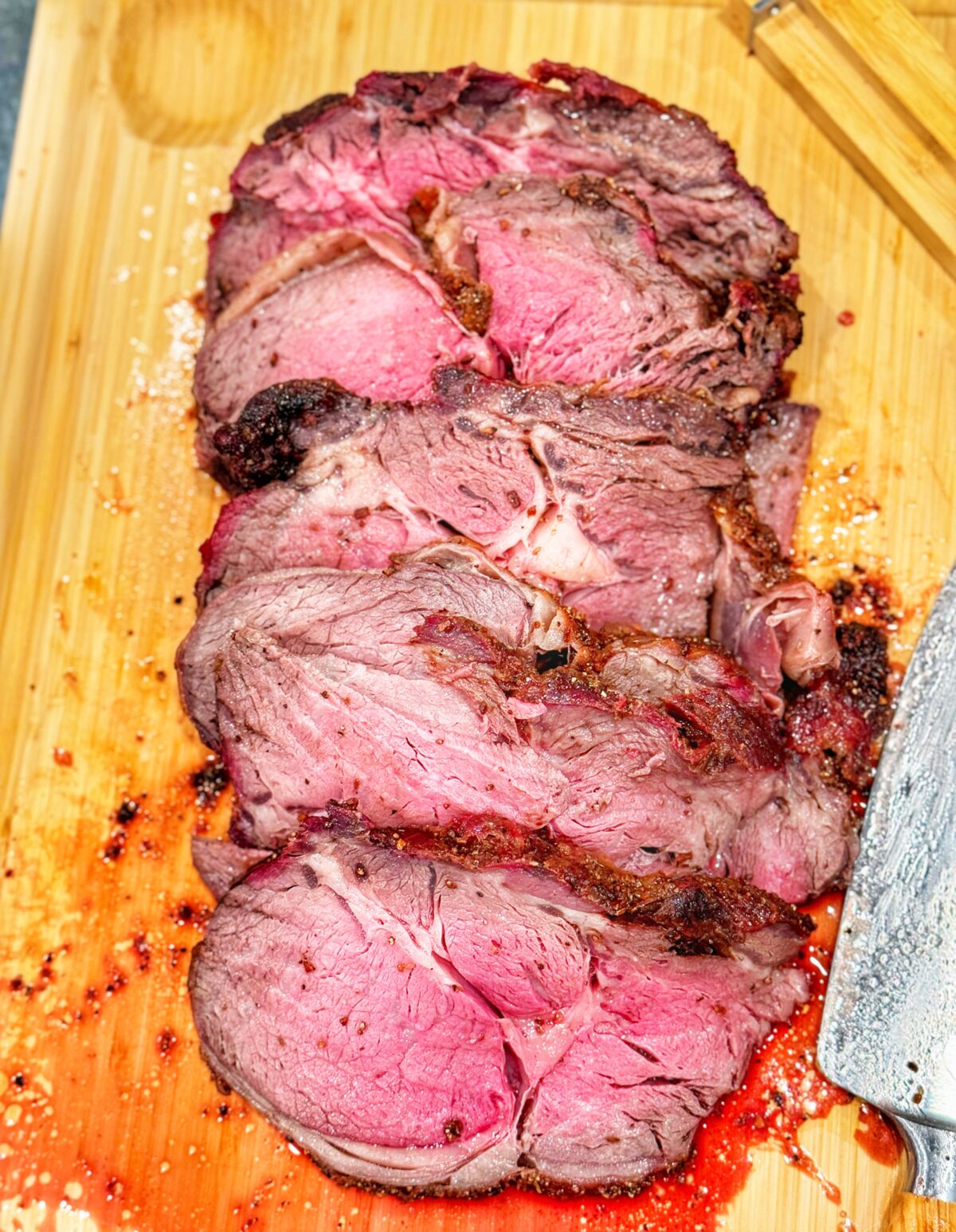 Sliced smoked-fried prime rib on a cutting board.