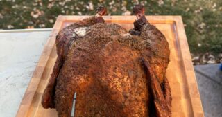 A smoked cajun turkey on a cutting board.
