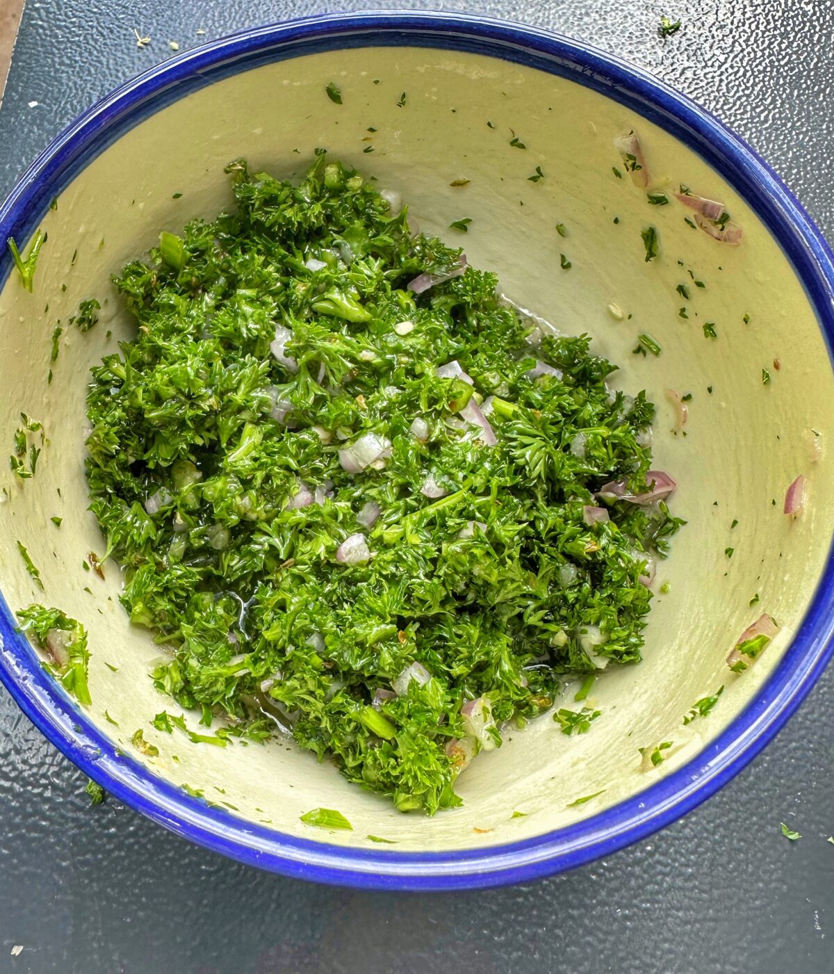 A bowl of chimichurri ready to be served with the New York Strip Roast.