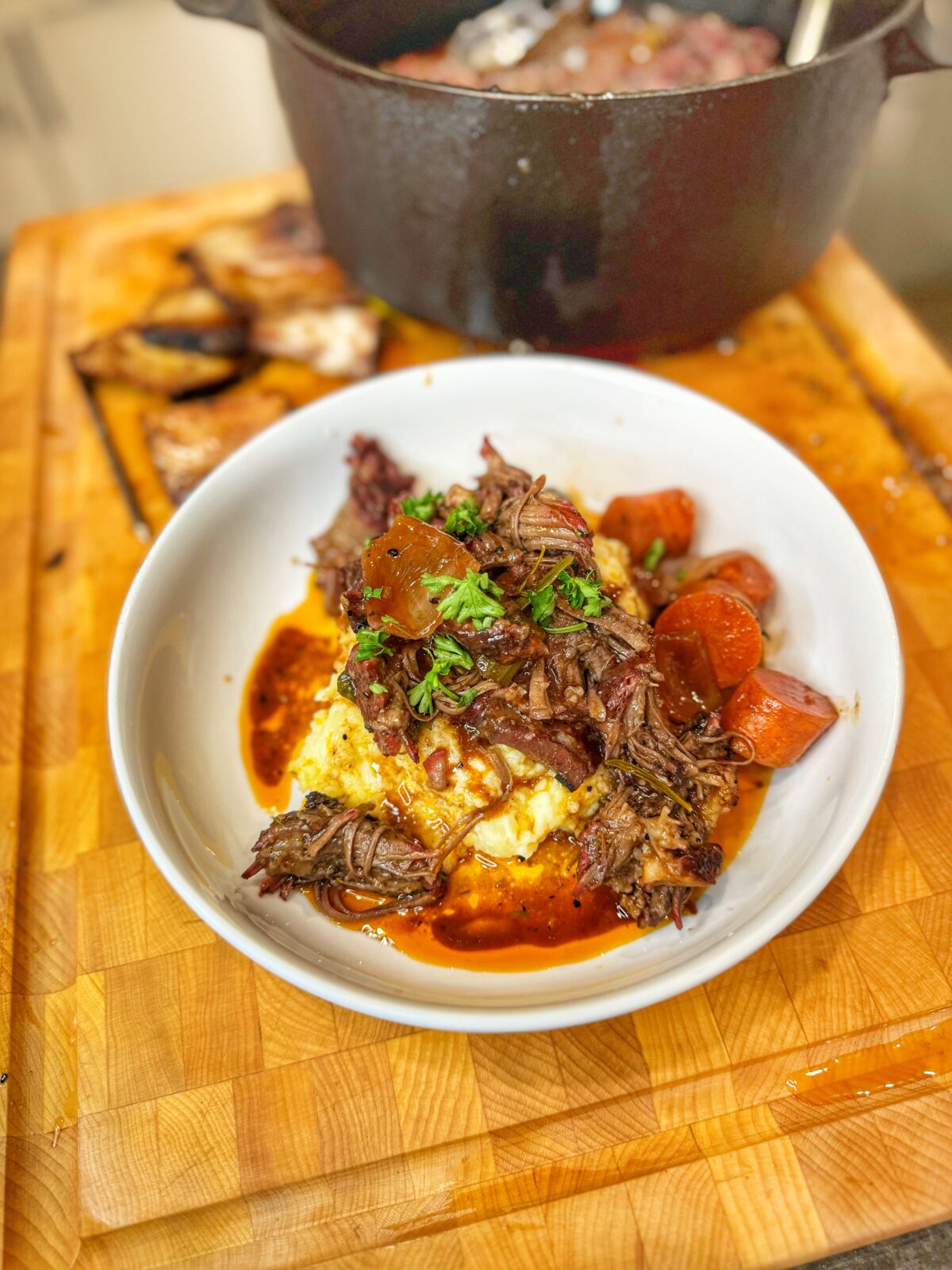 A bowl of red wine braised short ribs over mashed potatoes.
