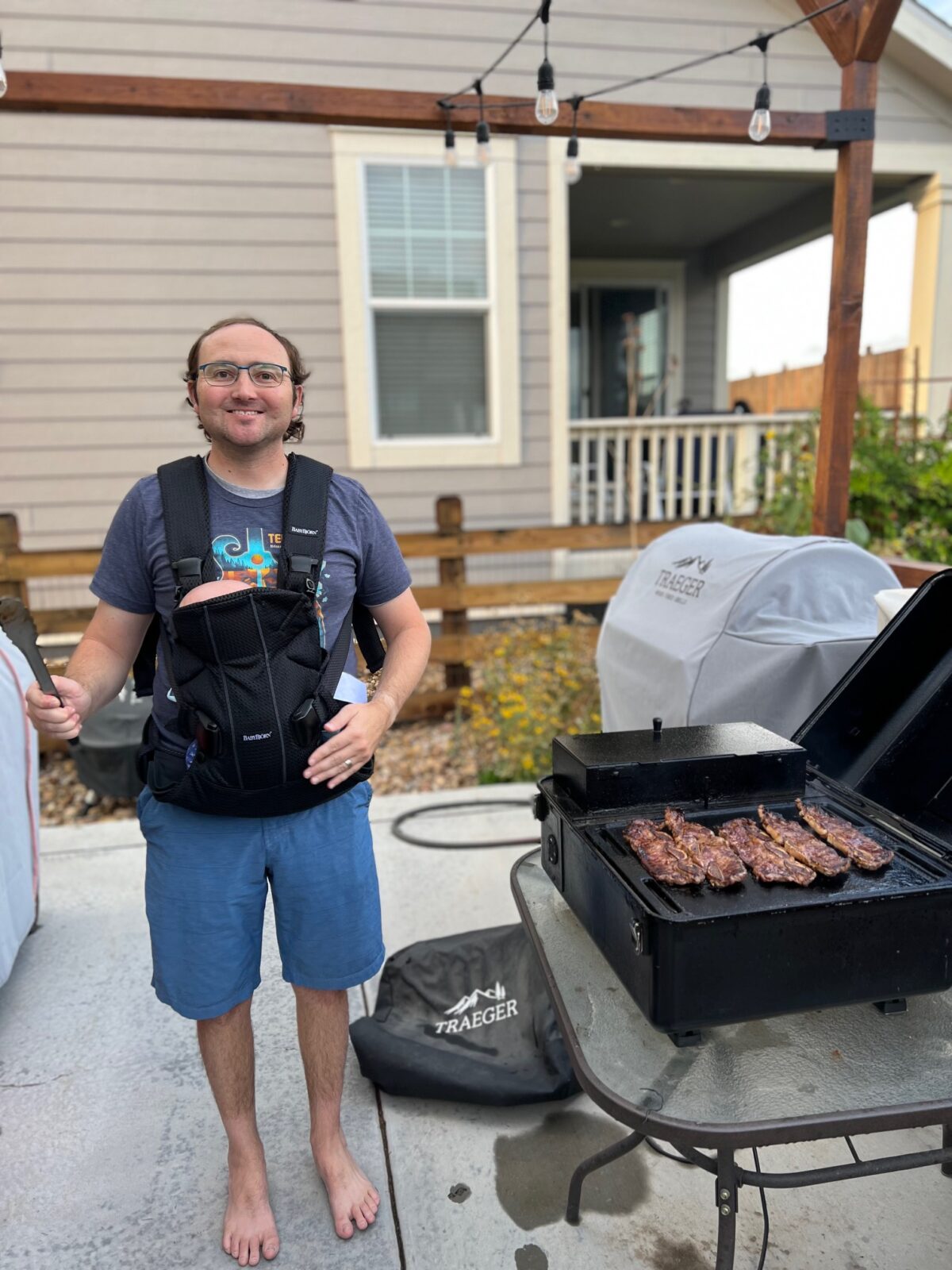 A man cooking on the Traeger Ranger in his backyard.