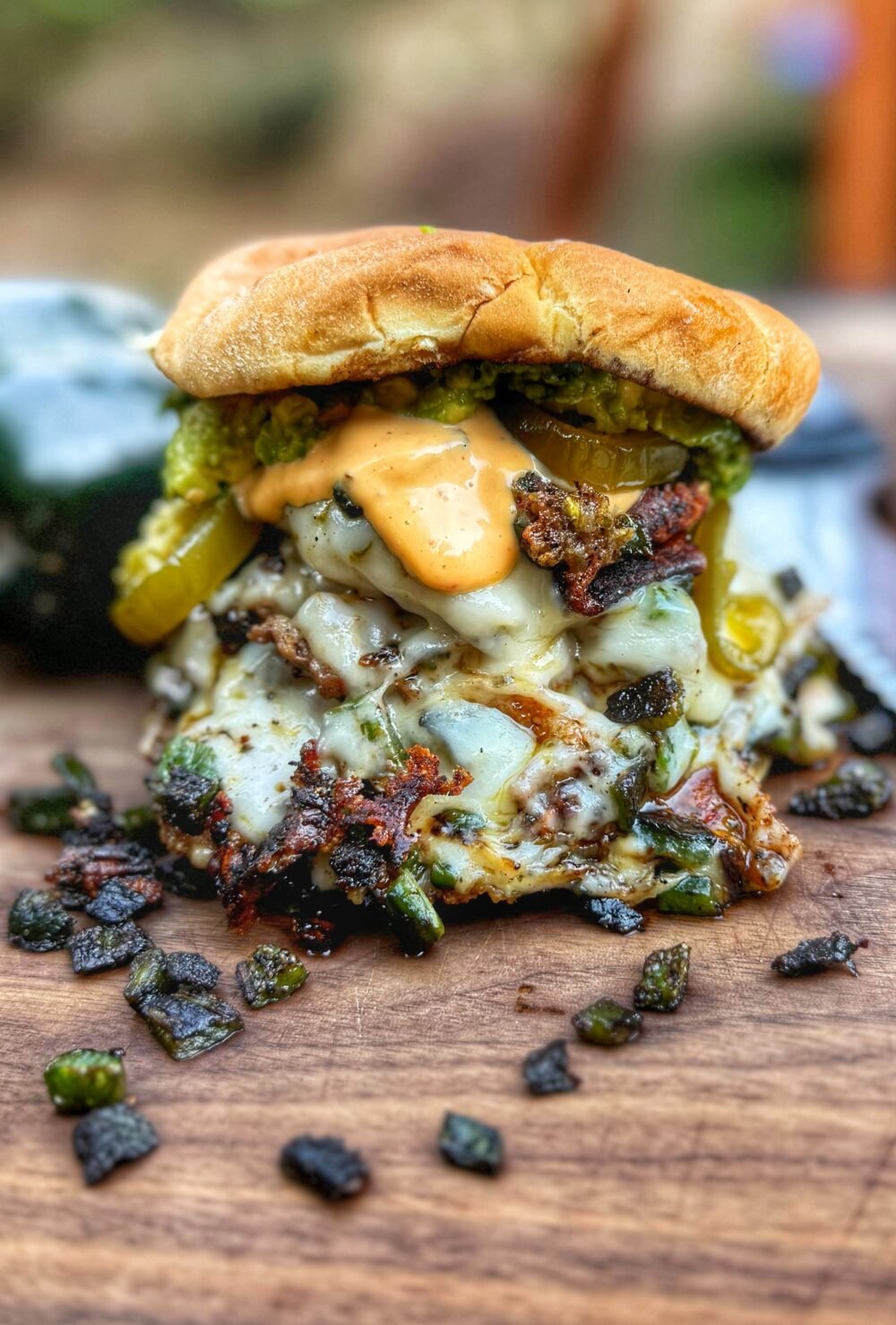 Roasted poblano smash burger stacked 4x4 style with pepper jack cheese, avocado, candied jalapeños, and aioli.