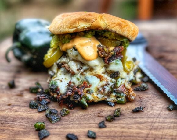 Roasted poblano smash burger stacked 4x4 style with pepper jack cheese, avocado, candied jalapeños, and aioli.