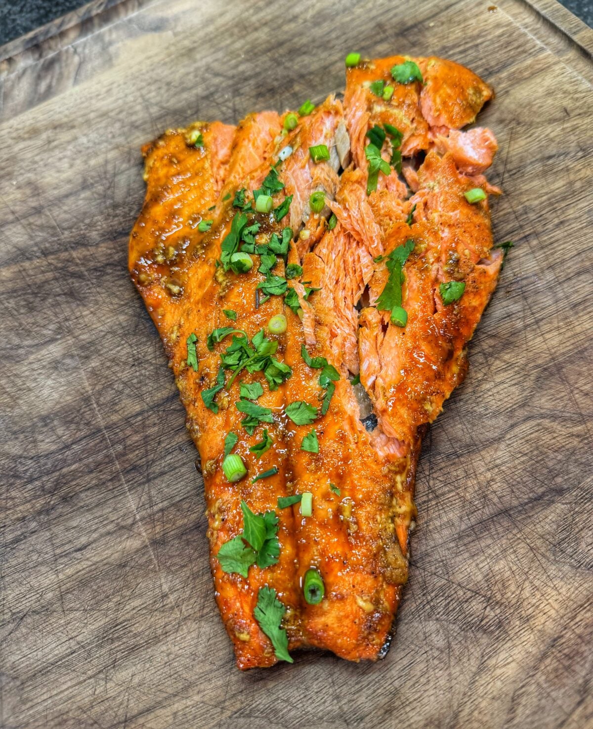 Flaked bourbon brown sugar salmon garnished with chopped cilantro and green onions.