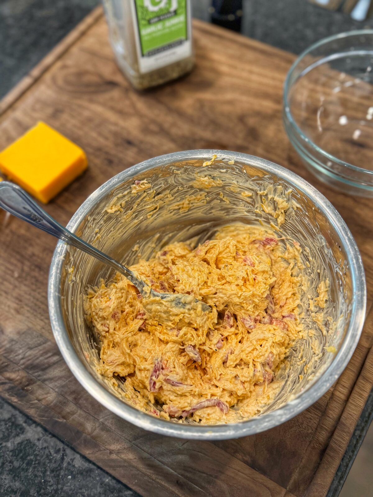 Fully mixed pimento cheese in a metal bowl showing a thick, creamy texture with visible shredded cheese and pimentos.
