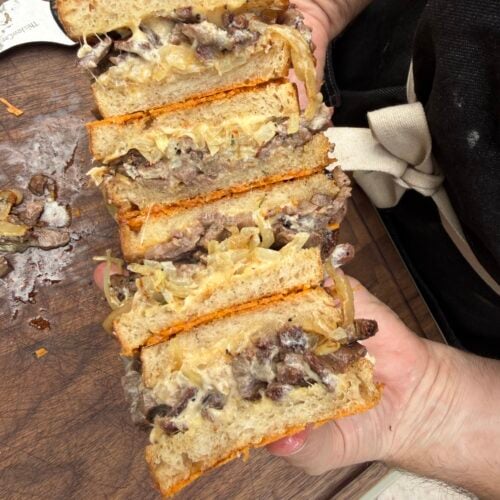Close-up of a sliced French Onion Steak Melt made with leftover smoked ribeye cap, caramelized onions, melted Cabot Gouda cheese, horseradish mayo, and Parmesan-crusted sourdough on a Pit Boss Griddle.