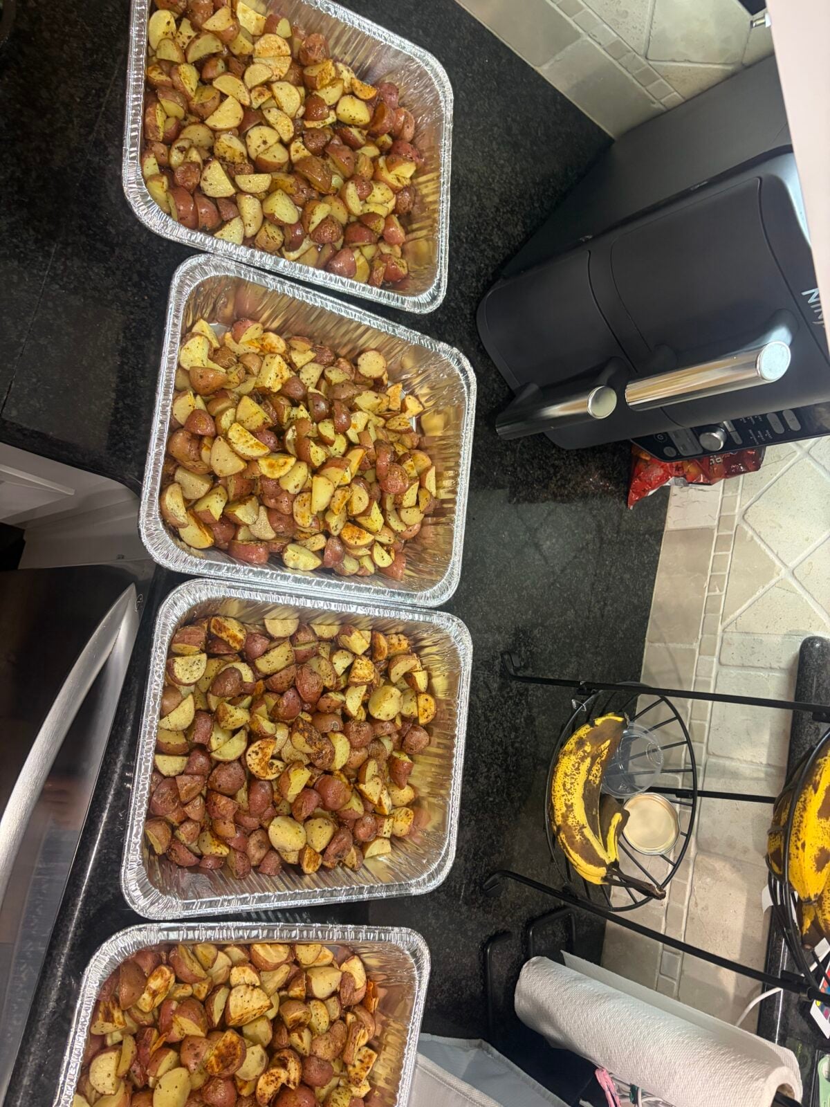 Four large pans of seasoned roasted red potatoes prepared for the McGuckin Hardware food demo.