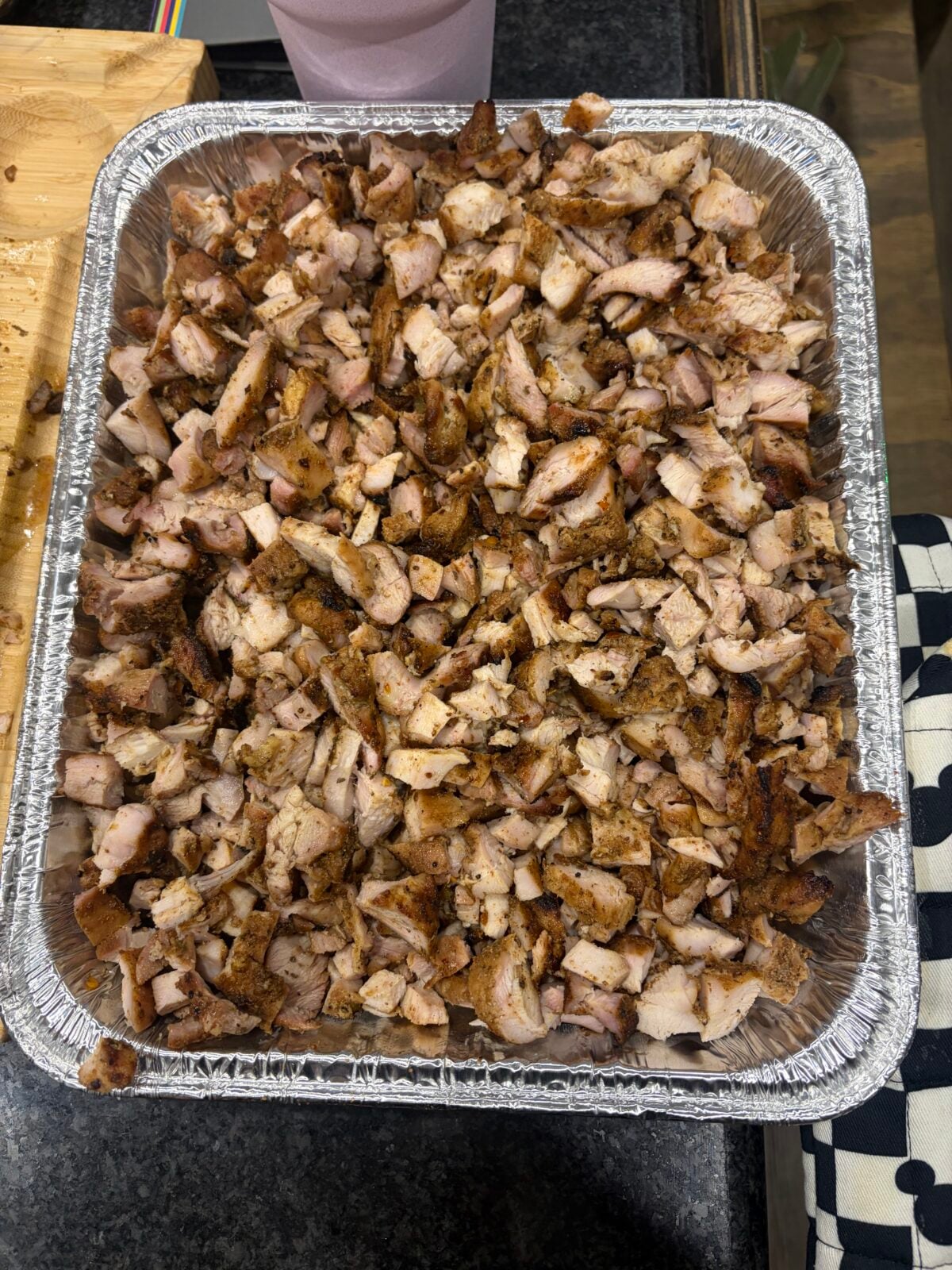 Large pan filled with chopped seasoned grilled chicken prepared for mini chicken tacos.
